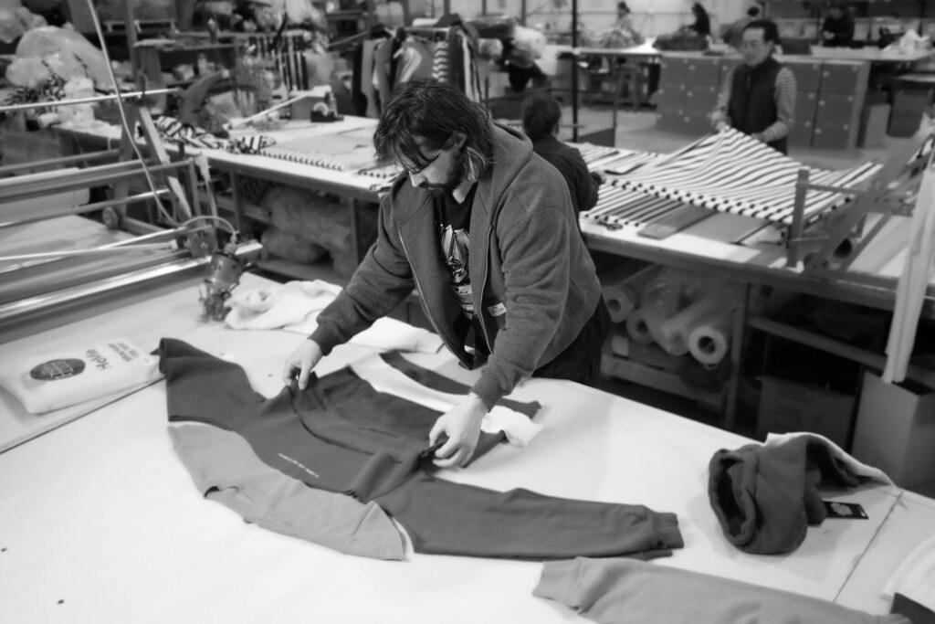 Photo of a man with long hair and beard in the process of making an orange and green sweatshirt