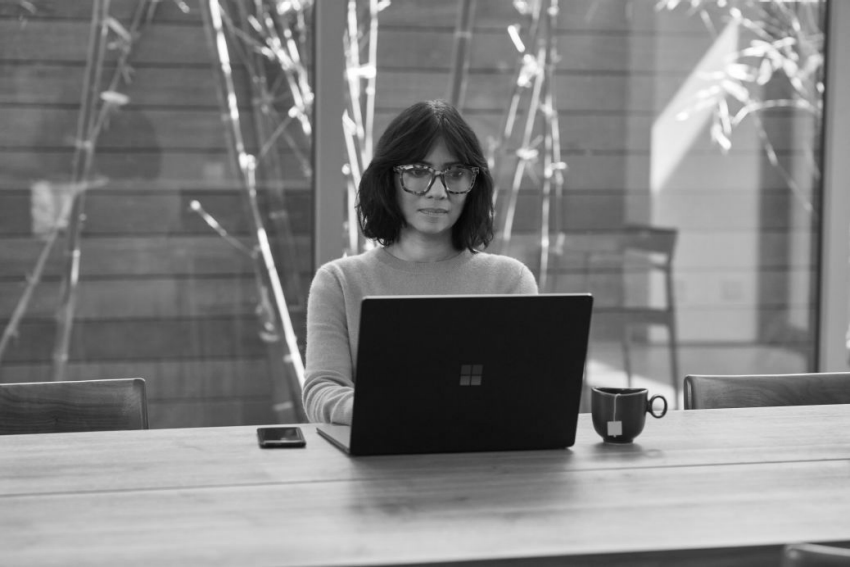 a woman sitting at a table with a laptop