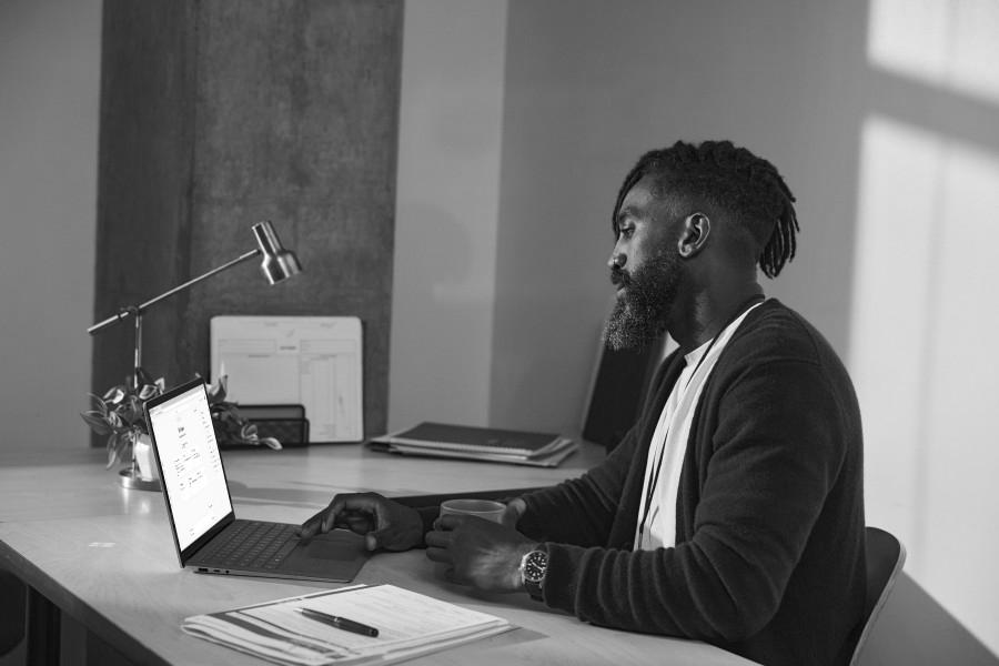 An Educator sits at a desk and uses Microsoft Copilot on a laptop.