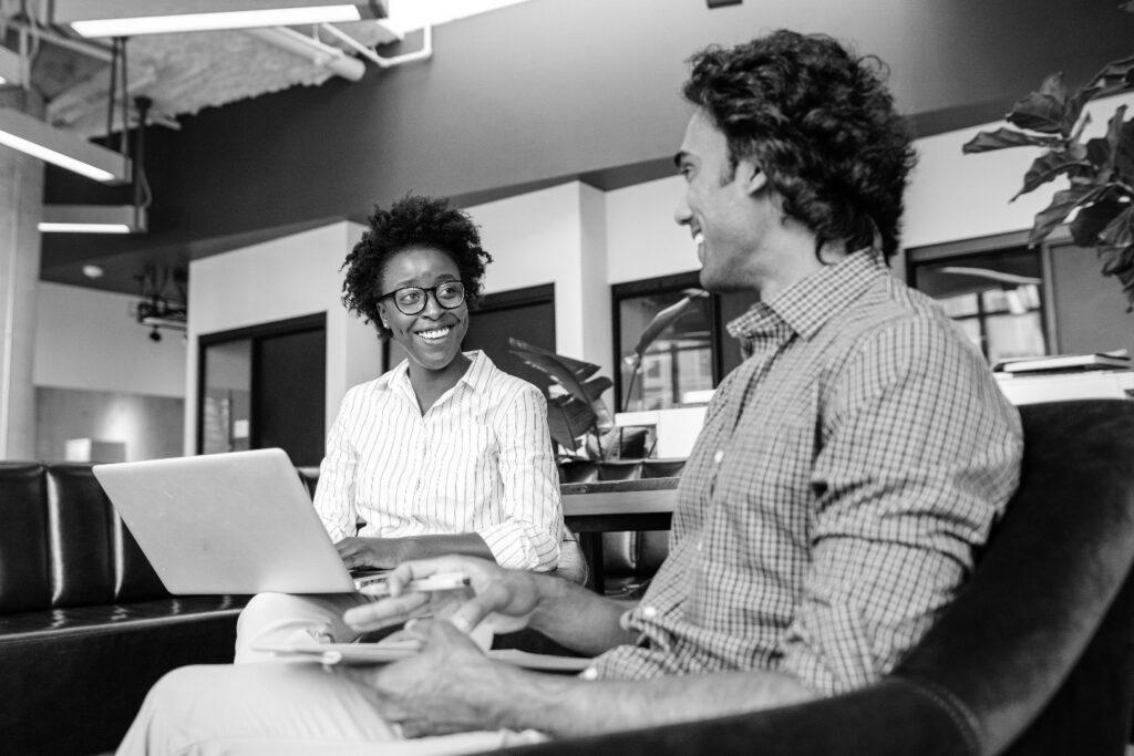 Two people sitting with a laptop